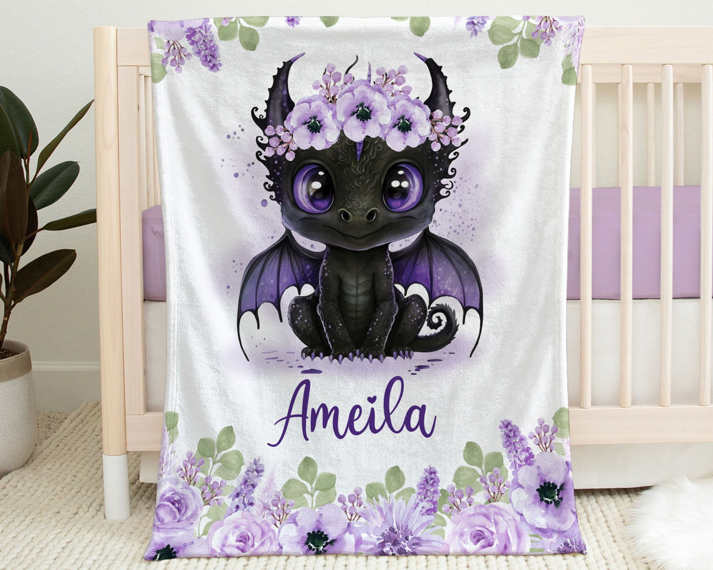 Personalized Baby Blanket hanging on the side of a crib. Blanket has an image of a Baby Dragon with Purple Flowers on Her head.