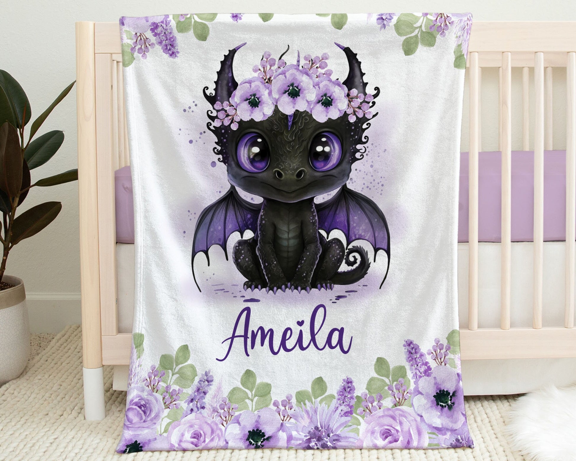 Personalized Baby Blanket hanging on the side of a crib. Blanket has an image of a Baby Dragon with Purple Flowers on Her head.