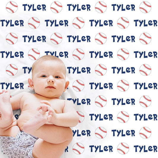Baby laying on blanket with baseballs and personalized with baby's name in blue.